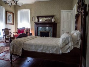 The Duncan bedroom with antique bed, fireplace and other furnishings