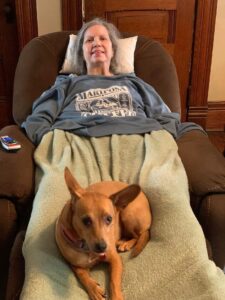 Woman in a recliner with a cute dog in her lap