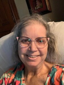 Woman with thinning gray hair and glasses