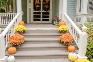 front porch steps decorated with colorful mums and pumkins