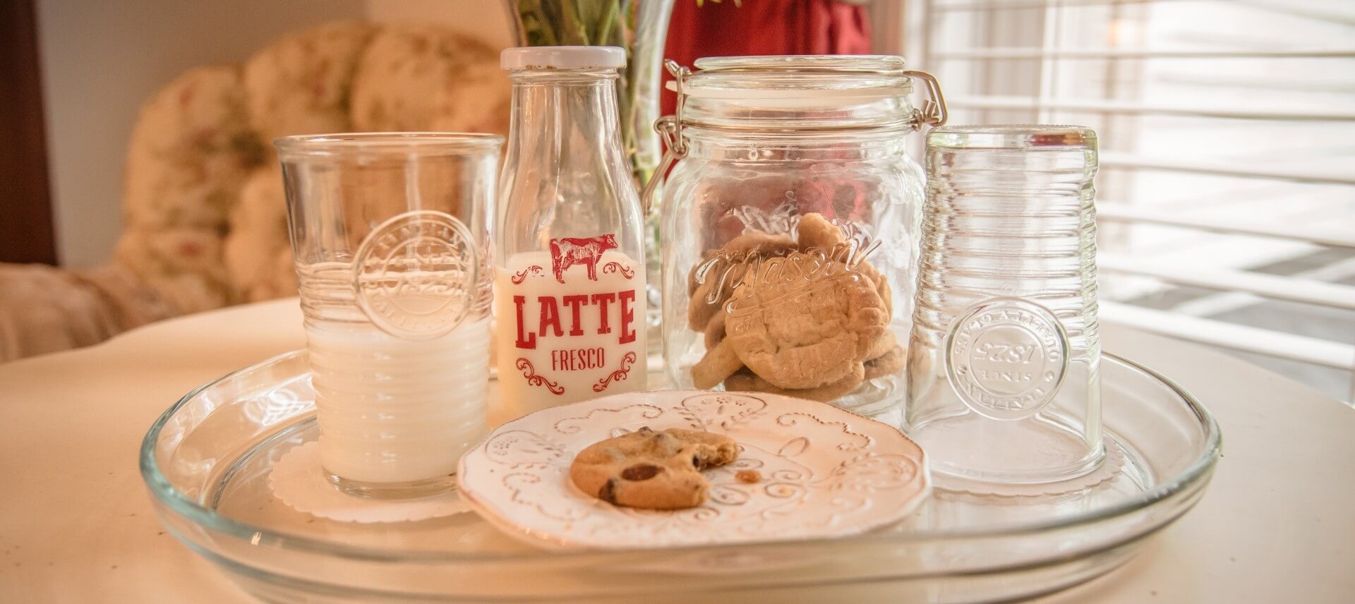 Latte milk bottle and mason style cookie jar with cookies and a cookie on a plate