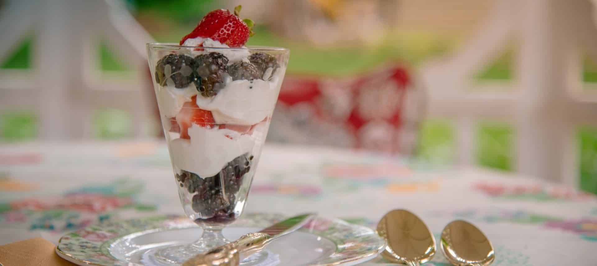 Blackberry, strawberry fruit parfait in glass on top of fine china